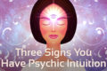 illustration of woman with eyes shut and third eye on forehead. purple background and text at the bottom which says 'Three signs you have psychic intuition'