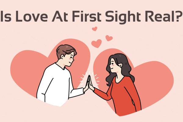 'is love at first sight real?' text with graphic of two people in hearts looking at each other and touching hands